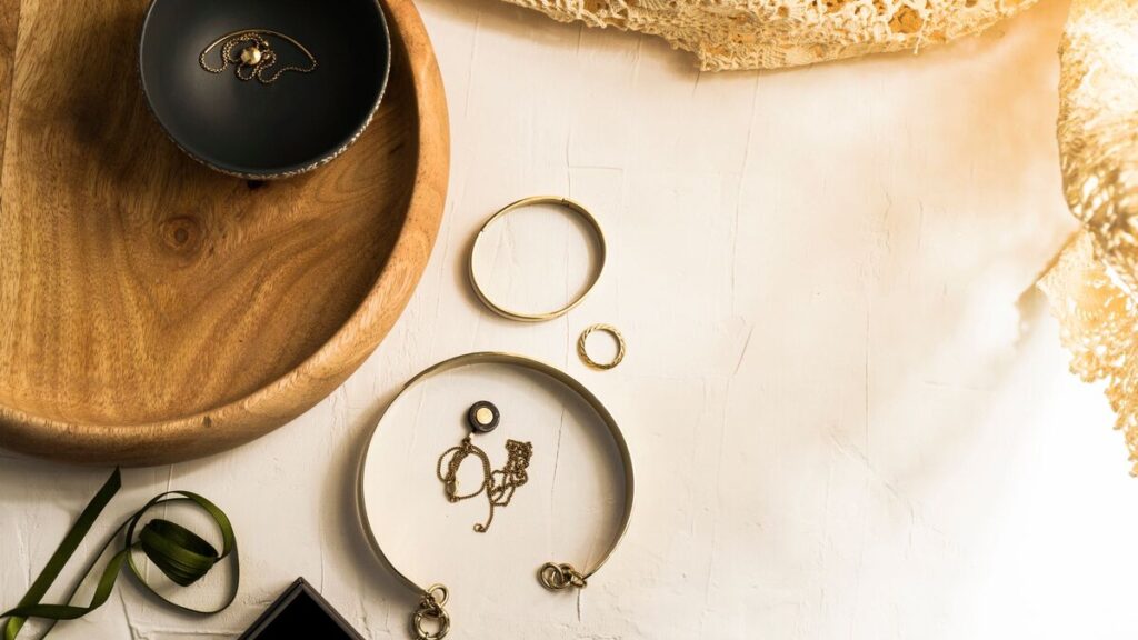 Bijoux de fantaisie, colliers et bracelets posés côte à côte sur un fond clair