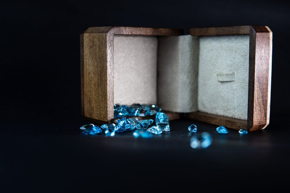 Boîte à bijoux ouverte posée sur une commode, bagues et chaînes visibles