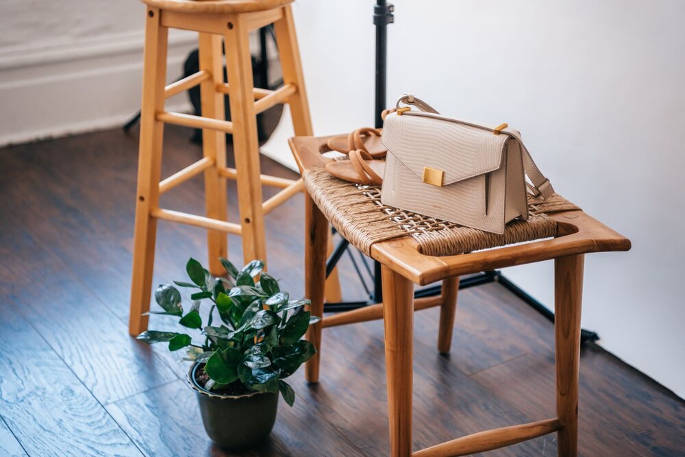 Sac noir posé sur le dossier d'une chaise en bois dans un intérieur
