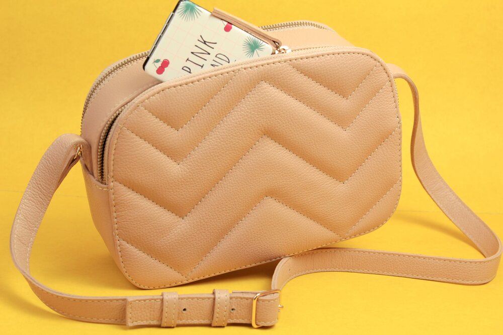 Bandoulière d'un sac réglée sur l'épaule, la boucle de réglage apparente
