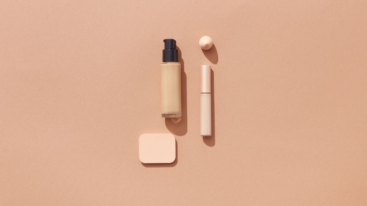 Flacon de fond de teint liquide posé près d'une éponge de maquillage