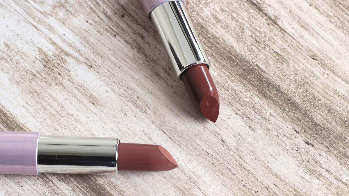Rouges à lèvres longue tenue ouverts et posés sur une table claire